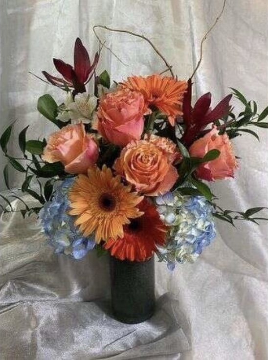 jamie kristens floral design coral, pink, red, light blue flowers in a dark vase