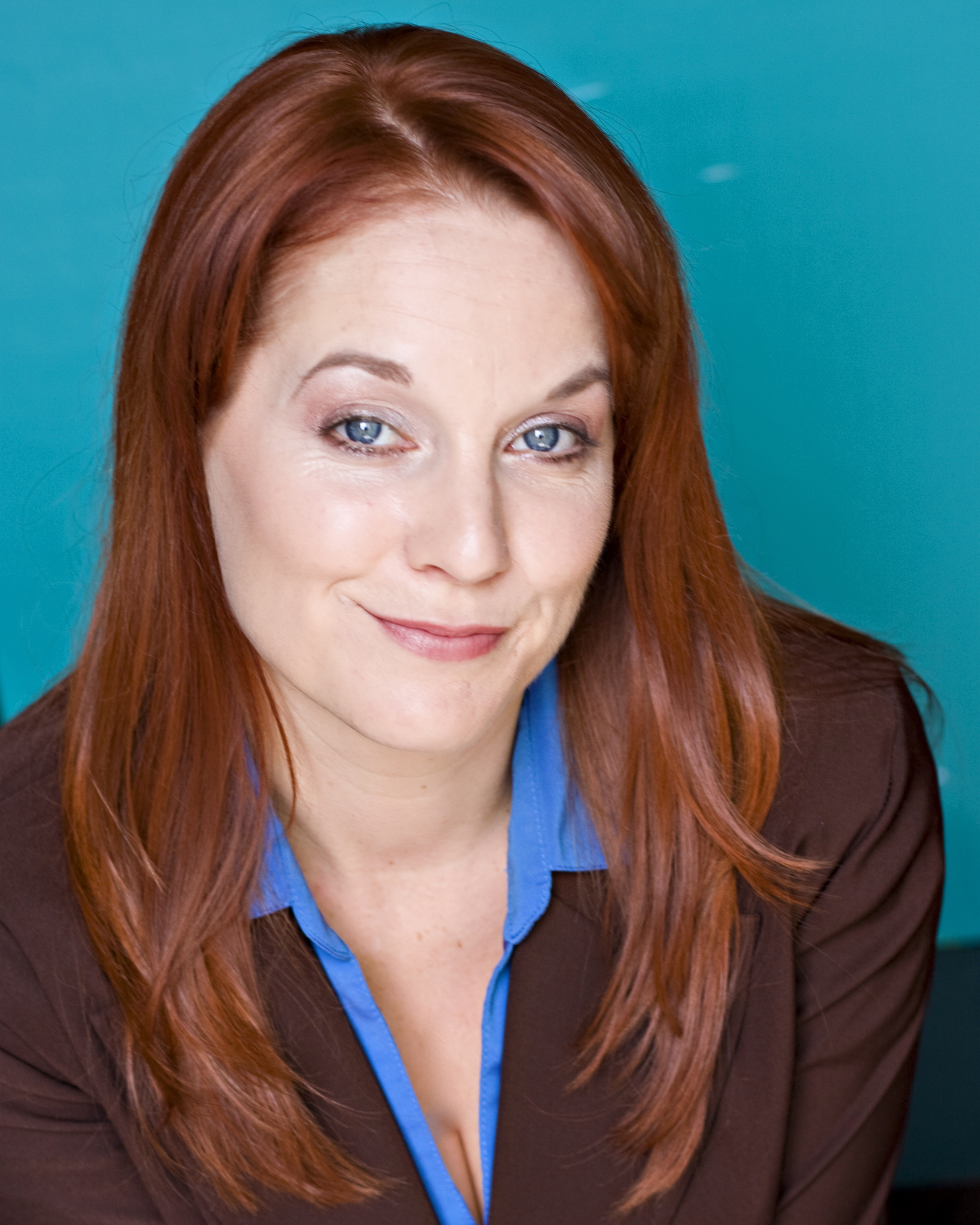 jamie kristen smirking, wearing business blue and brown blazer