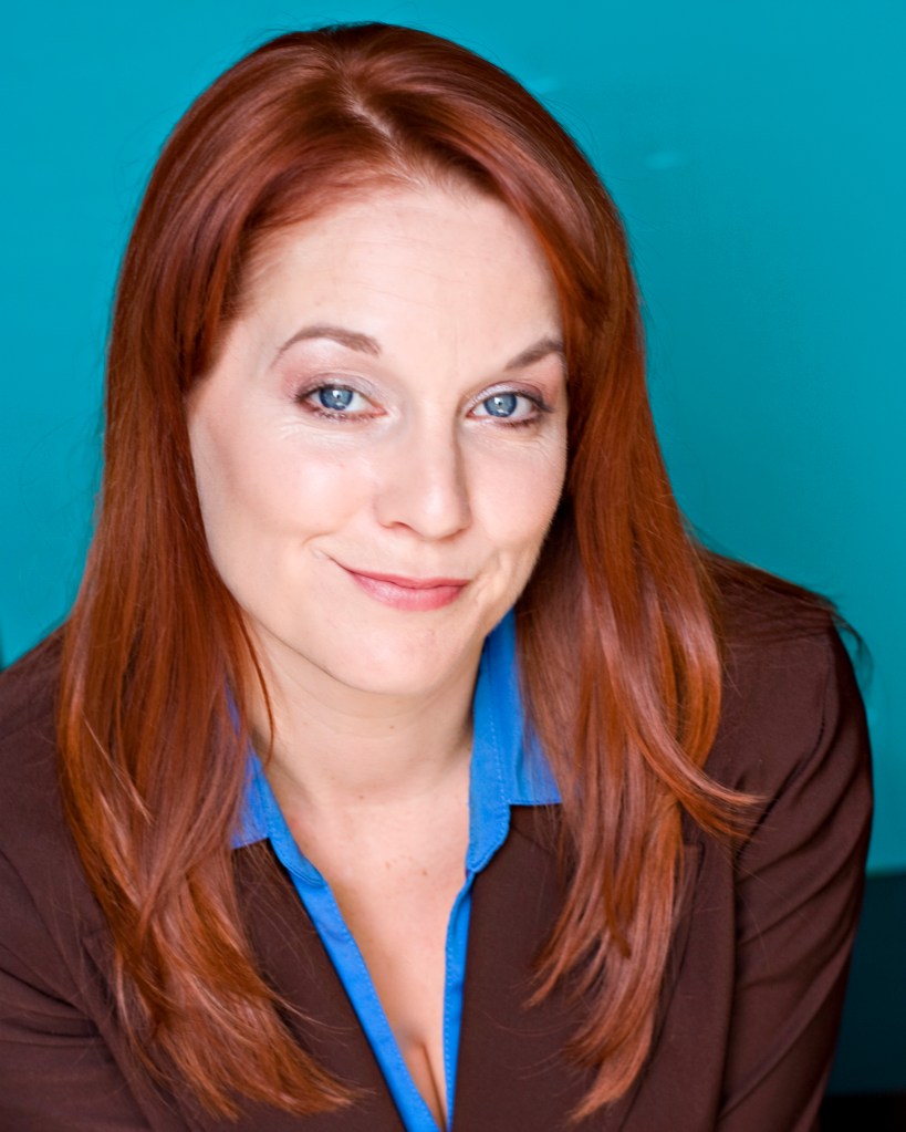 jamie kristen smirking, wearing business blue and brown blazer